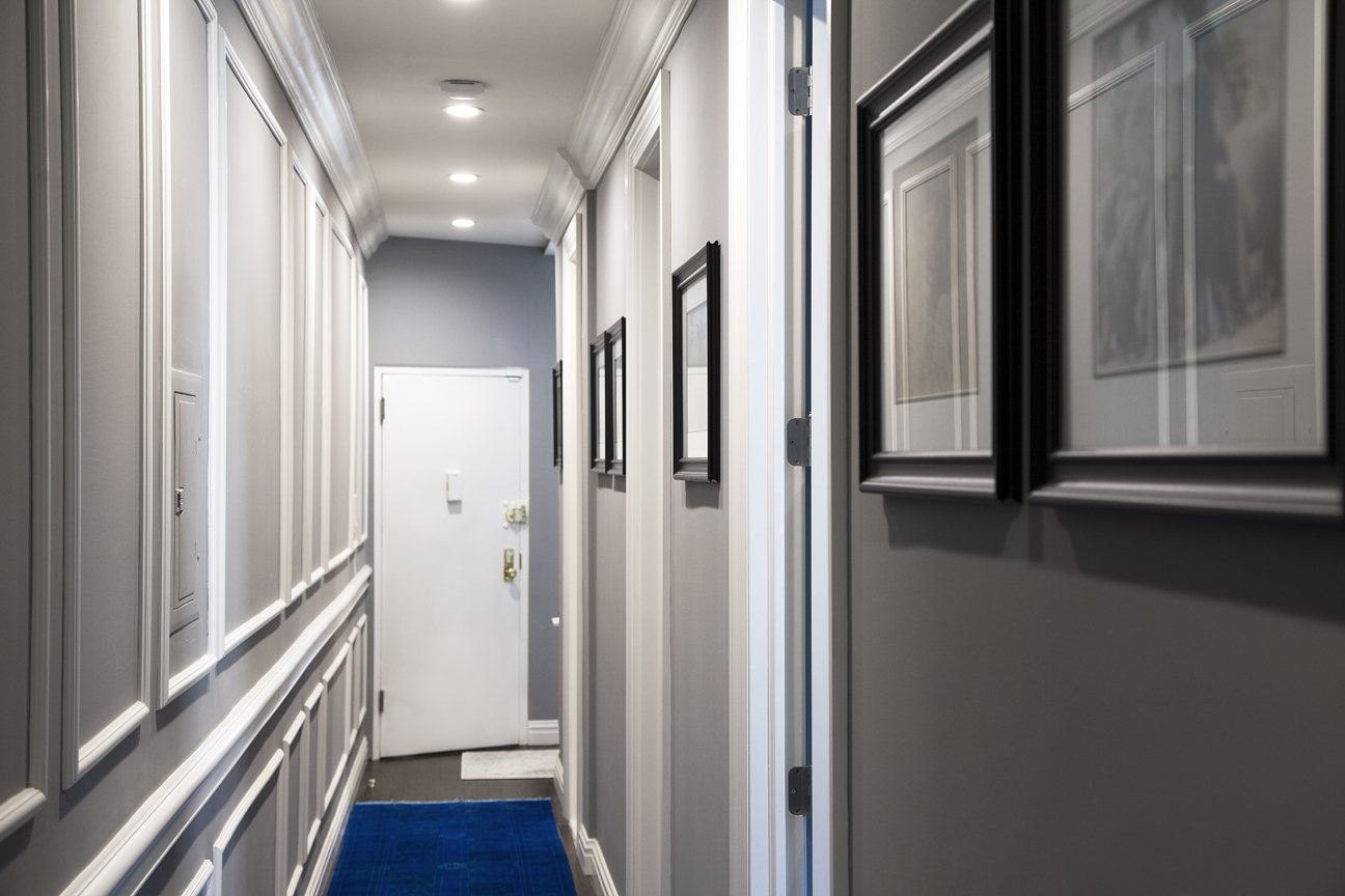 Cobble Hill project hallway with paneled wainscoting, crown moulding and framed artwork