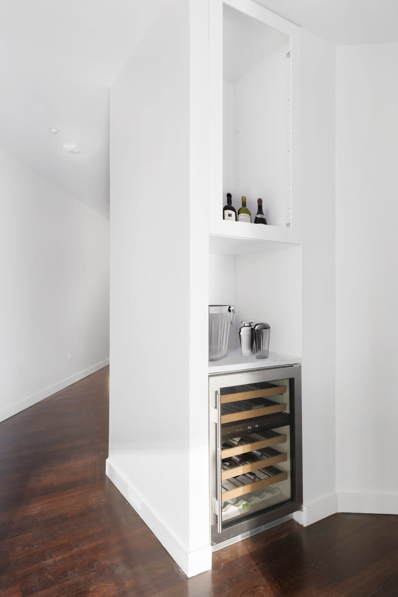 Tribeca II — dining room with a set table and upholstered chairs beside tall city-facing windows, with white built-in shelving and dark hardwood flooring — image 2 of 14