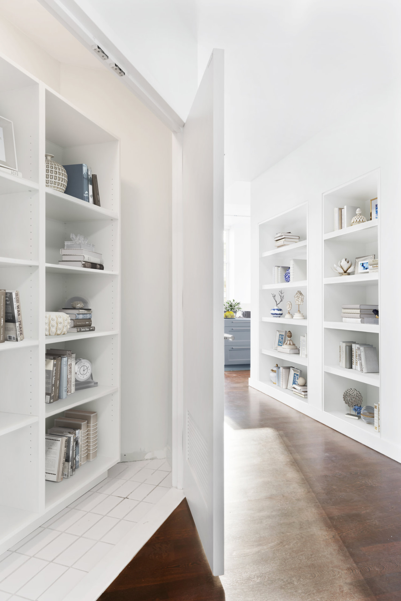 Tribeca II — dining room with a set table and upholstered chairs beside tall city-facing windows, with white built-in shelving and dark hardwood flooring — image 6 of 14