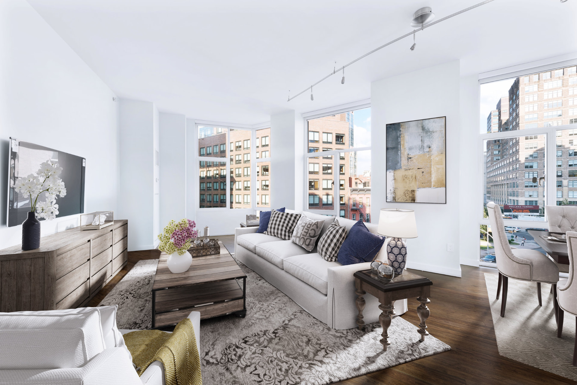 Tribeca II — dining room with a set table and upholstered chairs beside tall city-facing windows, with white built-in shelving and dark hardwood flooring — image 12 of 14