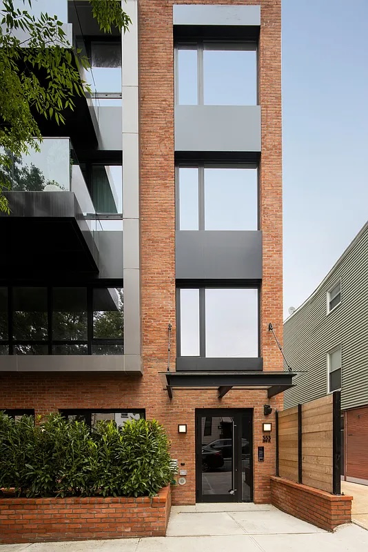Greenwood Heights — narrow rooftop terrace with pale stone pavers alongside black-framed windows and a clear sky — image 14 of 16