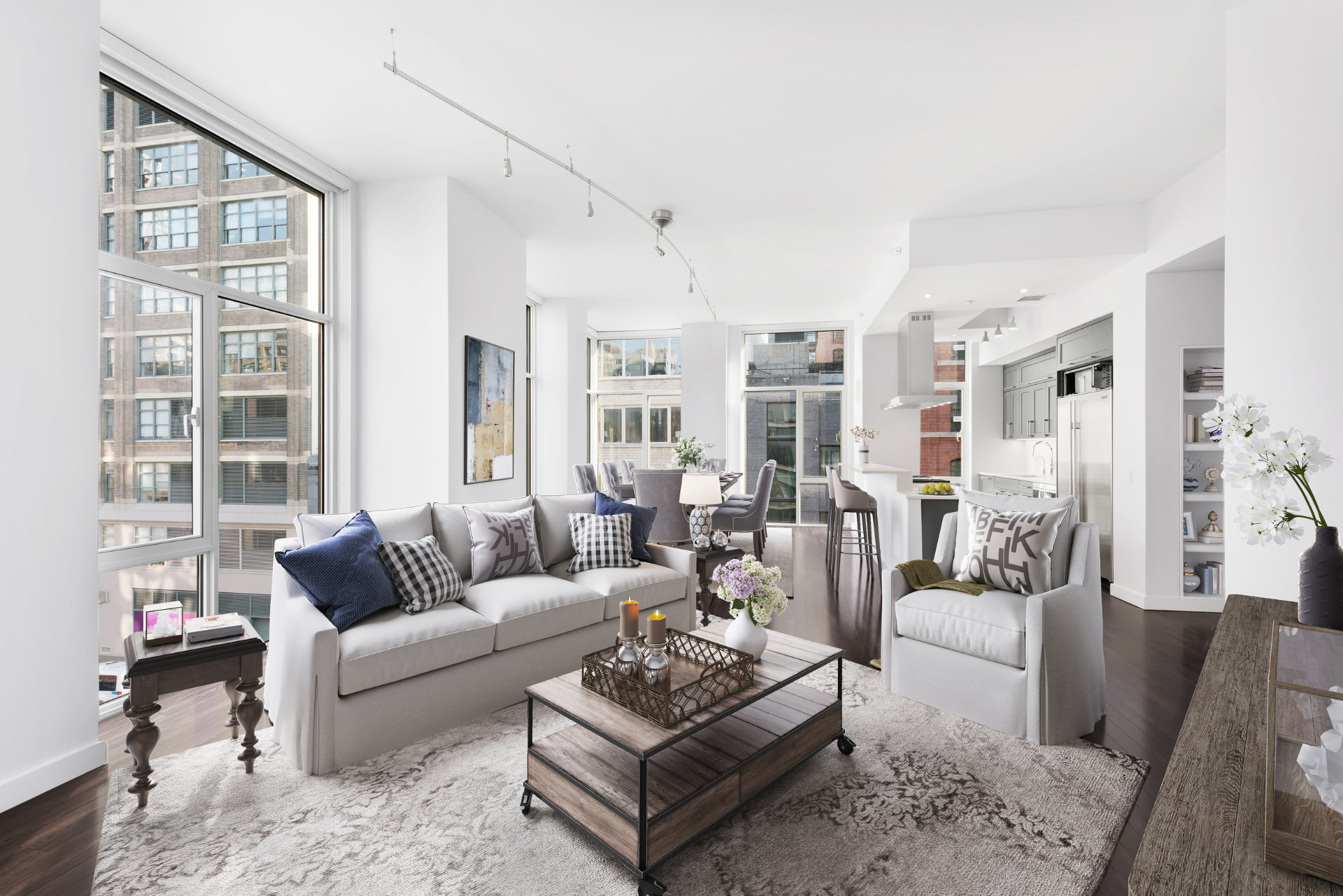 Tribeca II — dining room with a set table and upholstered chairs beside tall city-facing windows, with white built-in shelving and dark hardwood flooring — image 9 of 14
